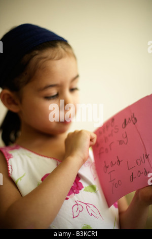 Bambina di cinque anni detiene la festa del papà card ha fatto di se stessa. "Felice la festa del papà per mio papà mi piace yoo papà". Foto Stock