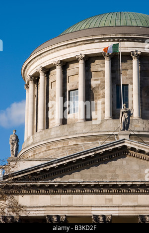Close up dettaglio mostrante statue di pietra, colonne e bandiera irlandese sul tetto del Four Courts Edificio, Dublino, Irlanda Foto Stock