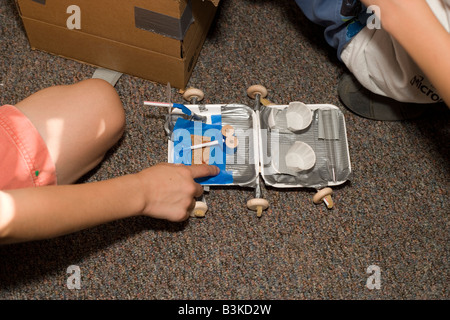 Spazio di giocattoli realizzati artigianalmente da materiale riciclato, realizzati da giovani i bambini a scuola di scienza camp Foto Stock