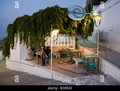 Persone rilassante in taverna al crepuscolo, Lindos, Rodi, Grecia Foto Stock