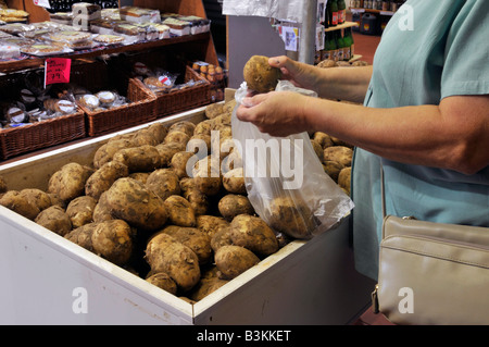 All'interno del Calcott Hall, negozio di prodotti agricoli al dettaglio, donna in esposizione, acquirente self-service, selezione di patate in sacchetto di plastica Brentwood Essex Inghilterra Regno Unito Foto Stock