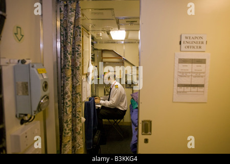 Un armi Engineering Officer lavora nella sua cabina a bordo quarti HMS vigili, un britannico classe Vanguard sottomarino nucleare Foto Stock