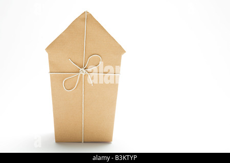 Studio shot del modello di casa avvolta in carta marrone e legati con spago Foto Stock