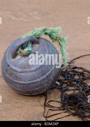 Vecchio galleggiante in metallo da una zona di pesca i pescherecci con reti da traino net galleggiante era realizzato in Spagna e nella foto lavato fino su una spiaggia della Cornovaglia U K Foto Stock