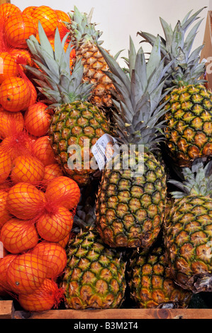 All'interno di Calcott Hall, negozio di frutta, prodotti da frutta in esposizione da vicino di ananas e sacchetti di arance Brentwood Essex Inghilterra Regno Unito Foto Stock