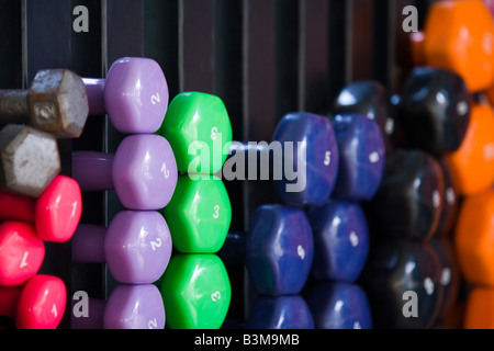 Closeup multicolore di pesi su un rack in un fitness studio Foto Stock