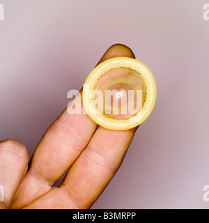 Il preservativo sulla mano d'uomo, vista in elevazione, close-up Foto Stock