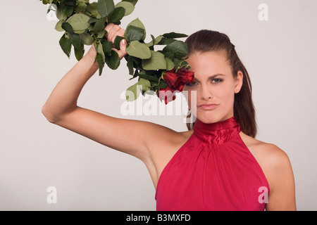 Giovane donna tenendo un mazzo di rose Foto Stock