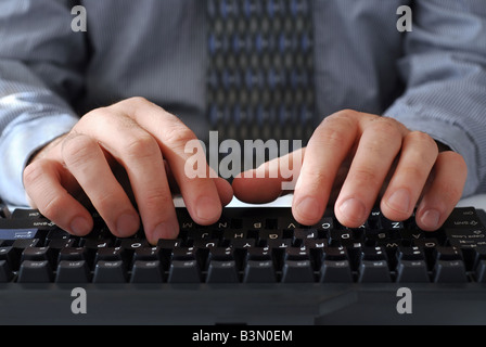 Primo piano dell'uomo s mani digitando su una tastiera Foto Stock