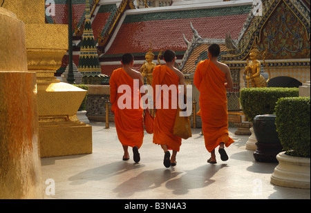 Tre i monaci buddisti il Grand Palace di Bangkok, Thailandia Buddismo abiti dello zafferano arancione vesti la religione Spititual educazione religiosa Foto Stock