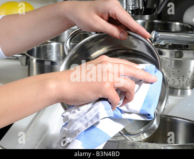 Donna essiccamento pentole e padelle Foto Stock