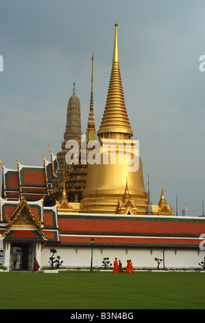 Il Grand Palace di Bangkok, Thailandia. Viaggiare in Asia i monaci del Buddismo Zafferano arancione vesti towers spires Foto Stock