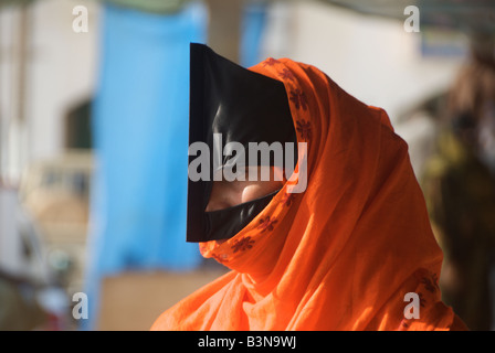 Close up beduino donna vestita di nero e arancio burka Sinaw Regione Sharqiya Sultanato di Oman Foto Stock