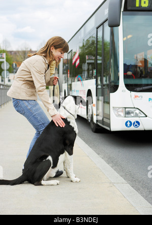 Donna con metà del cane di razza - in piedi alla strada / Foto Stock