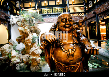 Il bronzo statua del Buddha dentro una piscina laghetto con paesaggio di roccia Foto Stock