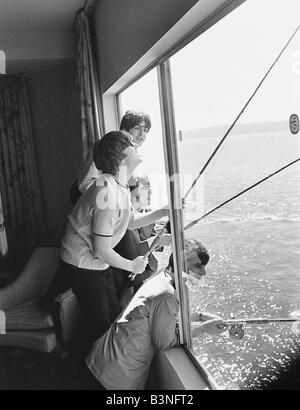 I file dei Beatles 1964 John Lennon Paul McCartney George Harrison e Ringo Starr pesca in Puget Sound dal loro albergo in finestra Foto Stock