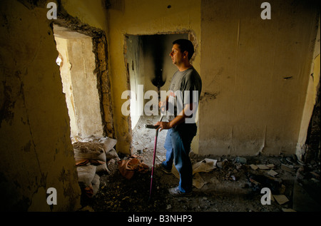 Mostar, giugno 1996', Alen kaytaz,ex combattente e ferito 3 volte nella stessa gamba, sorge in resti di un edificio, 1996 Foto Stock