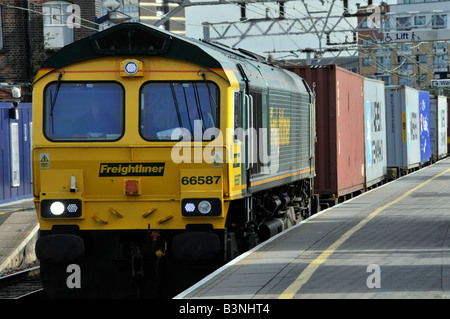 Stratford East London Freightliner locomotore 66587 con un contenitore treno merci Foto Stock