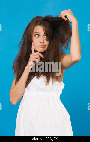 Giovane donna strappando i suoi capelli, ritratto Foto Stock