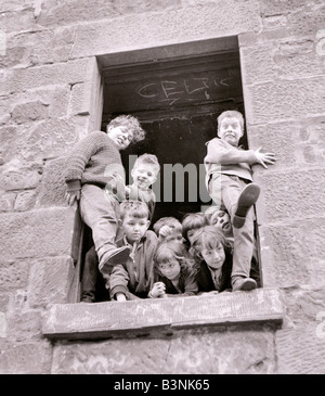 Alloggiamento baraccopoli nella Gorbals distretto di Glasgow dove i bambini giocano nelle finestre di case abbandonate Giugno 1966 Foto Stock
