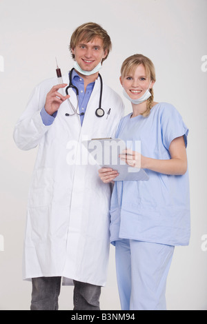 Coppia giovane indossando Doctor's complessivamente, sorridente Foto Stock