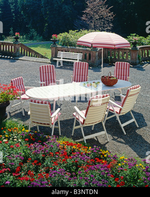 Mobili da giardino poltrone ed ombrellone decorata con rosa in tessuto a righe Foto Stock