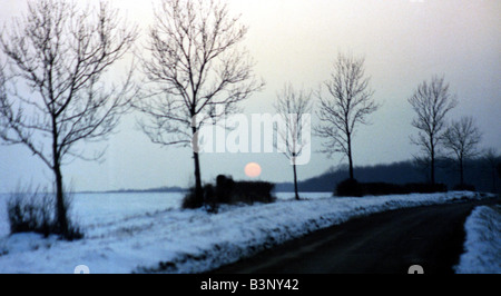 La metà del sole invernale lentamente set su un paesaggio di Hertfordshire crepuscolo rimane del giorno Dicembre 1989 Foto Stock