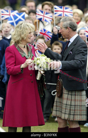 Carlo e Camilla aperto il nuovo parco giochi per bambini a Ballater Scozia Aprile 2005 il Principe di Galles Duchessa di Cornovaglia Principessa consorte apparizione pubblica sulla loro luna di miele fucsia cappotto rosa abito con rivestimento in tartan come il collare Kilt e tuta giacca con cravatta Highland abbigliamento moda union jack onda bandiere in background Foto Stock