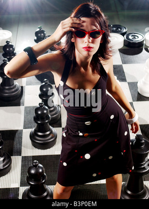 Emily modellazione moda Scacchi Giugno 2003 indossando occhiali da sole rosso e un abito nero con il bianco a pois tenendo la mano alla sua testa Foto Stock