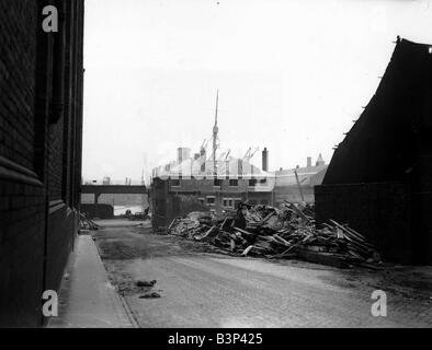 WW2 Raid aereo bomba di Liverpool danneggiare i bombardamenti su resti di edifici amministrativi e magazzini a Liverpool docks a seguito di un raid aereo dalla Luftwaffe German Airforce durante il blitz di 1940 1941 Liverpool era il porto principale di entrata per materiale bellico proveniente attraverso l'atlantico dagli USA Questo lo ha reso un bersaglio primario per la Luftwaffe navi ormeggiate al dockside in background Foto Stock