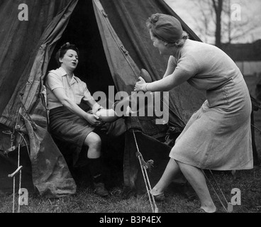 Dando una mano sul terreno di scena a Blunham Bedfordshire volontario agricoltura camp dove la guerra dei lavoratori in vacanza sono trascorrere la Pasqua a lavorare sulla terra Vice camp operaio Bobbie Wormington aiuta a tirare fuori Barbara Dent s gumboots Foto Stock