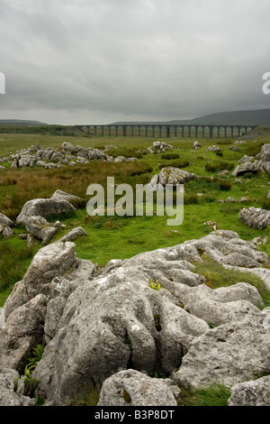 Pavimentazione di pietra calcarea con Ribblehead il viadotto in distanza, Ribblesdale, Yorkshire Dales, North Yorkshire Foto Stock