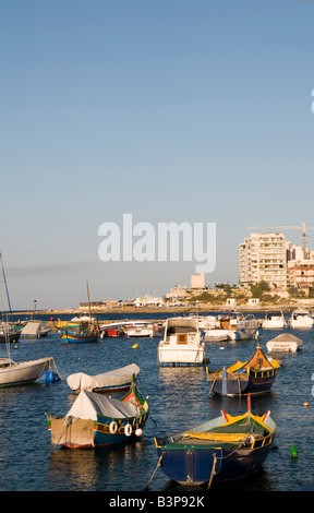 Malta il maltese luzzu classico pesca barche da pesca nel porto di St Julian s paceville sliema allo scempio condominiums Foto Stock