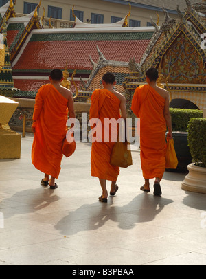 Tre monaci buddisti, il Grand Palace di Bangkok, Thailandia. Monaco buddista di accappatoi Safrron visitando il palazzo. Foto Stock