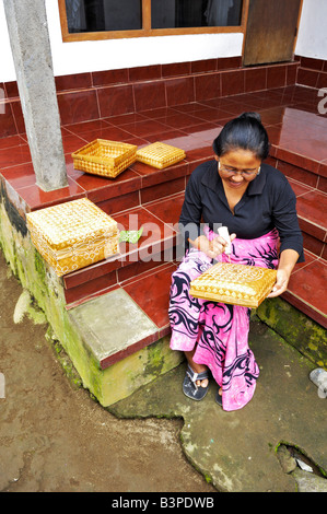 Villaggio tradizionale, una donna balinese decorazione di scatole di vimini in Bangli Bali, Indonesia Foto Stock