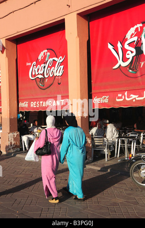 Due donne velate di fronte arabo coca-cola annuncio nella piazza Djemma El Fna, "impostore Square' o 'Square dell'impiccato" Foto Stock