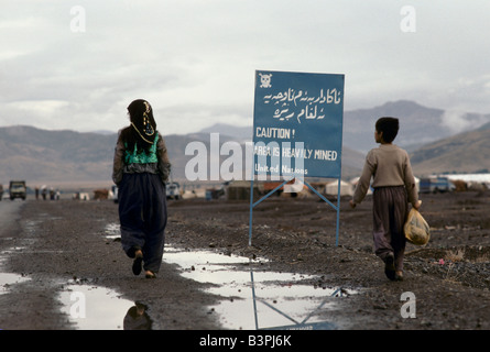 Il Kurdistan', due persone a piedi passato NAZIONI UNITE segno di avvertimento del pericolo delle mine inesplose, PENJUIN, ottobre 1991 Foto Stock