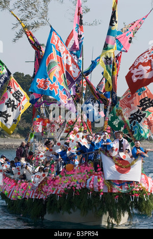 Barca da pesca decked out in banner colorati e cantare i membri dell'equipaggio per la Ose Matsuri festival nei pressi di Numazu Giappone Foto Stock