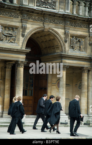 Esame di Oxford gli studenti vestito in abiti e gonne e portante mortarboards a piedi passato l'esame scuole. Foto Stock