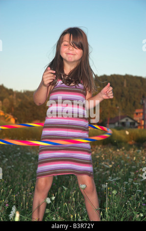 Bambina giocando con il cerchio di plastica ritratto Foto Stock