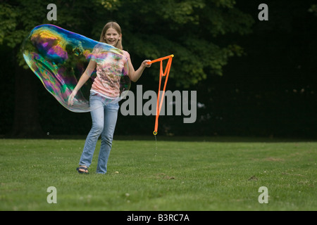 Giovane ragazza che effettuano grandi bolle di sapone Foto Stock