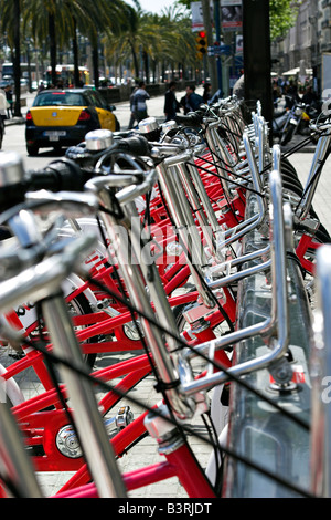 Noleggio di biciclette allineate in un rack in un pomeriggio soleggiato a Barcellona, Spagna Foto Stock