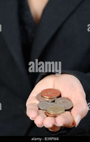 Donna che mantiene una manciata di monete Britanniche Close Up Foto Stock