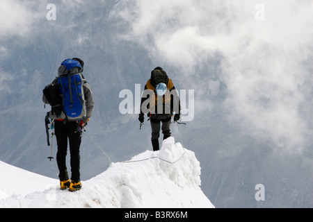 Due alpinisti cautamente scendere dal vertice del Aigulle du Midi vicino a Chamonix Mont Blanc nelle Alpi francesi Foto Stock