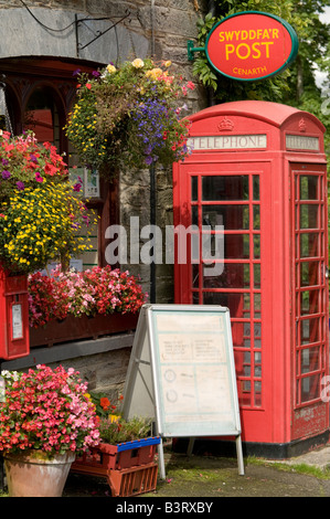 Tradizionale in rosso nella casella Telefono esterno Cenarth Ufficio postale nel negozio di paese Ceredigion West Wales UK Foto Stock