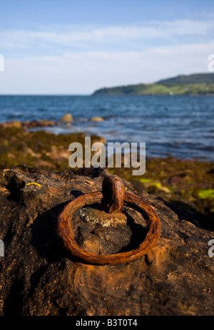 Un anello di ferro annegate in una roccia sulla spiaggia a Brodick sull'isola di Arran nel sud-ovest della Scozia Foto Stock