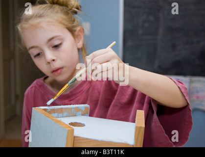 Ragazza giovane pittura a birdhouse Foto Stock