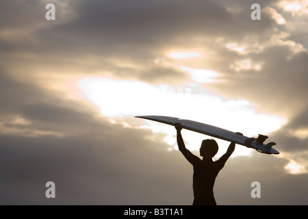 Un surfista su Muriwai Beach, Nuova Zelanda Foto Stock