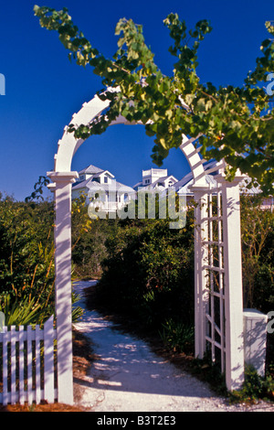 Seaside Florida Walkway bianco con arco in legno e piante verdi edifici color pastello in background Foto Stock