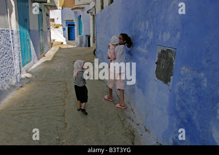 Ragazza adolescente passeggiate per le strade di Chefchaouen con sorelle minori nelle prime ore del mattino. Foto Stock